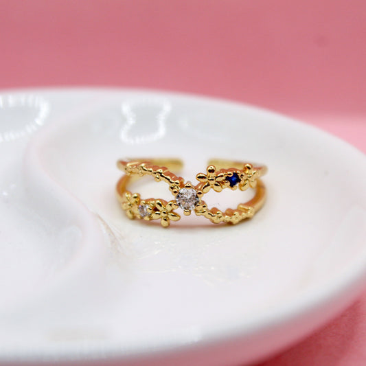 ANILLO X CON FLORES LISAS Y ZIRCONIAS BLANCAS Y AZULES